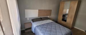 een kleine slaapkamer met een bed en een spiegel bij Tenerias 2 in Castellón de la Plana
