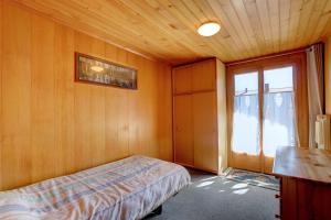 1 dormitorio con cama y ventana en Appartement Les Cascades, en Château-d'Oex
