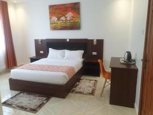 een slaapkamer met een bed en een bureau met een telefoon bij 401 Restaurant & Accommodation in Naivasha