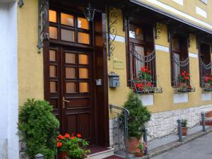 un edificio con una puerta de madera y flores en ollas en Ada Apartments, en Sarajevo