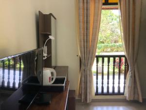 a desk with a computer on it next to a window at One-Room Homestay 81B Muar in Muar