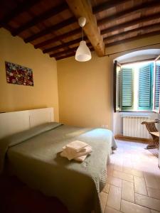 a bedroom with a bed in a room with a window at Casa Toscanella & Girasole in Pescia