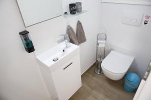 uma casa de banho com um lavatório branco e um WC. em Villa Klara em Vodice