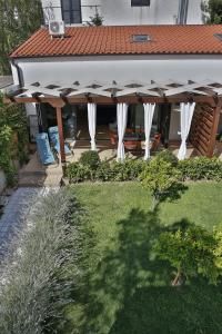 a patio with an umbrella in a yard at Villa Klara in Vodice