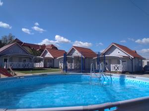 a swimming pool in front of some houses at Kotwicownia in Mikołajki
