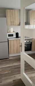 a kitchen with wooden cabinets and a white refrigerator at Tenerias 2 in Castellón de la Plana