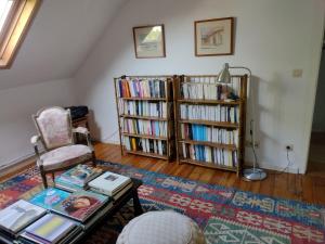 una sala de estar con 2 estanterías llenas de libros en L Heure Bleue, en Wezembeek-Oppem
