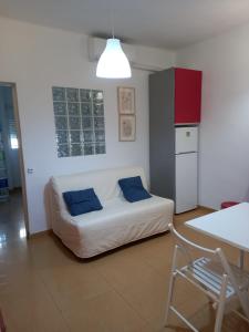 een woonkamer met een witte bank en blauwe kussens bij Riverside Triana in Sevilla