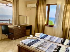 a bedroom with a bed and a desk and a window at Apolon Complex in Sozopol