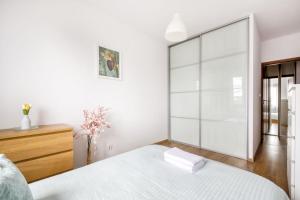 biała sypialnia z dużymi przesuwnymi szklanymi drzwiami w obiekcie Gama Home Wyspowa 1 w Warszawie