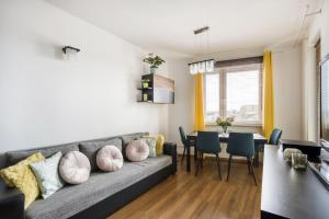 - un salon avec un canapé et une salle à manger dans l'établissement Gama Home Wyspowa 1, à Varsovie