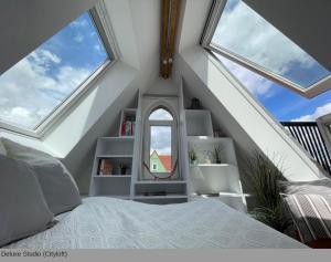 una camera da letto mansardata con letto e specchio di Lofts in Hannover ad Hannover