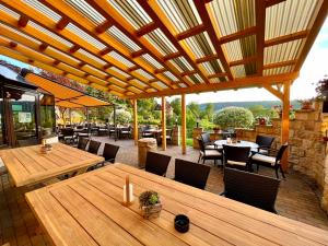 un patio al aire libre con mesas y sillas de madera en Naturhotel Gasthof Bärenfels en Kurort Altenberg