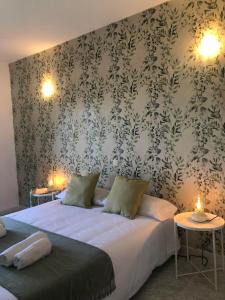 una camera da letto con un grande letto e carta da parati floreale di El Lago a Cervera de Buitrago