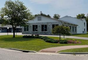 a house with a landscaping in front of it at Lighthouse View Motel in Mackinaw City