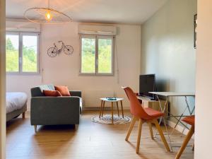 - un salon avec un canapé et une chaise dans l'établissement Appartement proche Hôpital et centre-ville, à Saint Lo