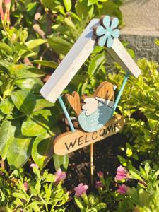 a welcome sign in a garden with a bird at Mini-Appartamenti, Camere Lanterna Blu in Mombello Monferrato