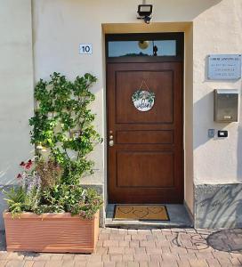 una porta di legno con due piante davanti di Mini-Appartamenti, Camere Lanterna Blu a Mombello Monferrato