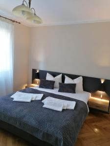 a bedroom with a large bed with two pillows at Apartament Alena in Baile Felix