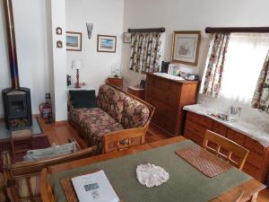 ein Wohnzimmer mit einem Sofa und einem Tisch in der Unterkunft Clarens Mountain Sage Cottage in Clarens