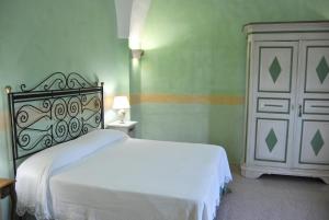 a bedroom with a white bed and a white cabinet at Anticadimora Dei Pepe in Salve