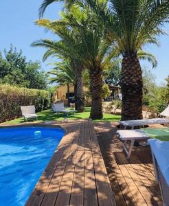 een zwembad met twee palmbomen naast een huis bij Casa vacanze La Posada in Partanna