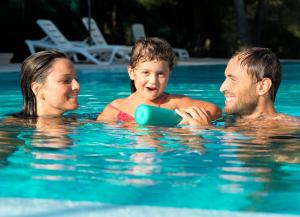 un uomo, una donna e un bambino in una piscina di Gattarella Family Resort - Seaside Rooms and Suites with Premium Half-Board à la carte a Vieste