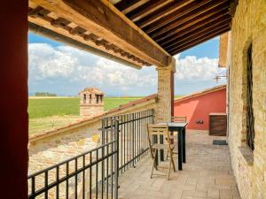 a balcony with a table and a view of a field at Villaluce Wine Agriturismo in Castiglione del Lago