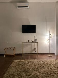 sala de estar con TV en una pared blanca en Suite Copal, en Tecozautla