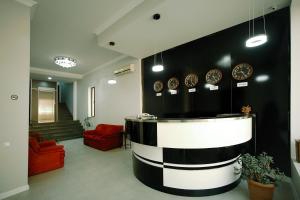 un vestíbulo con una pared en blanco y negro con relojes en Hotel Rero, en Kutaisi