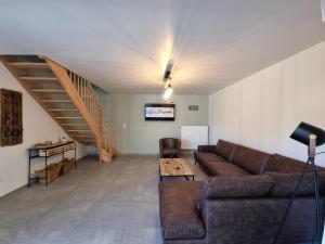 sala de estar con sofá y escalera en Les Cayaux en Brugelette