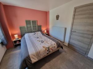 een kleine slaapkamer met een bed en een deur bij Les Cayaux in Brugelette