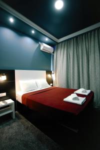 a bedroom with a red bed with towels on it at Hotel Rero in Kutaisi