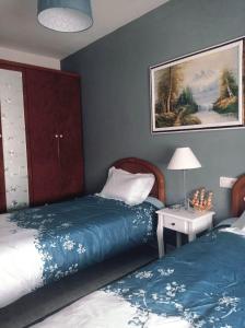 a bedroom with two beds and a table with a lamp at Apartamento Playa de Coto in Barreiros