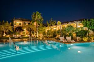a swimming pool in front of a building at night at Daluz Boutique Hotel in Preveza