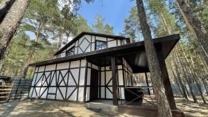 czarno-biały dom w lesie w obiekcie Orman Ski w mieście Shchuchinskiy