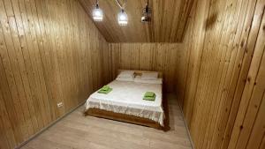 a small room with a bed in a wooden cabin at Orman Ski in Shchuchinskiy