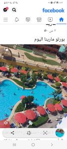 a screenshot of a page of a resort with two pools and umbrellas at Porto marina luxury flat for families onlyشاليه فاخرداخل بورتو مارينا in El Alamein