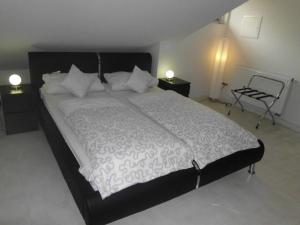 ein Schlafzimmer mit einem großen Bett mit weißer Bettwäsche und Kissen in der Unterkunft Villa Vogelsang, Schwimmbad, Sauna in Sierksdorf