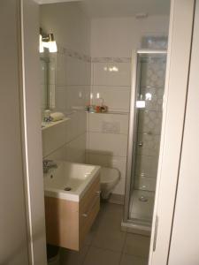 ein weißes Bad mit einem Waschbecken und einem WC in der Unterkunft Villa Vogelsang, Schwimmbad, Sauna in Sierksdorf