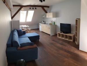 uma sala de estar com um sofá azul e uma cozinha em Apartamenty Generalskie em Borne Sulinowo