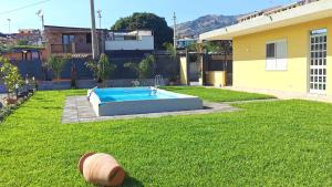 a yard with a swimming pool in the grass at La Villa Trinacria in Giardini Naxos