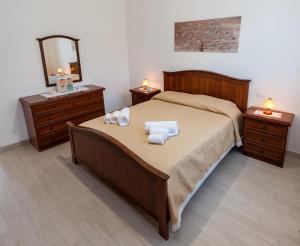 een slaapkamer met een bed met handdoeken en 2 nachtkastjes bij AL BARONE in Scopello