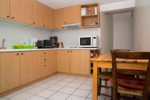 cocina con armarios de madera, mesa y microondas en Entre Lac et Montagne, en Veyrier-du-Lac