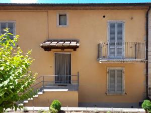 an orange building with stairs and windows and a balcony at La Casa di Valeria alle Serre in Serre di Rapolano