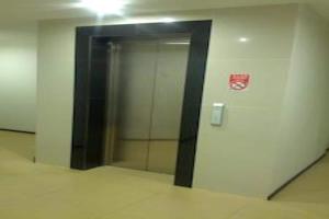 un ascensor en un edificio de oficinas con una puerta de cristal en Super OYO 90579 U Inn en Miri