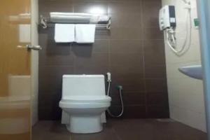 La salle de bains est pourvue de toilettes blanches et d'un lavabo. dans l'établissement Super OYO 90579 U Inn, à Miri