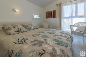 une chambre avec un lit avec une couette dessus dans l'établissement COSY LODGE TOULOUSE, à Toulouse
