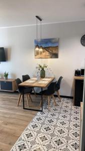 a dining room with a table and chairs on a rug at Apartament Tomek in Iława