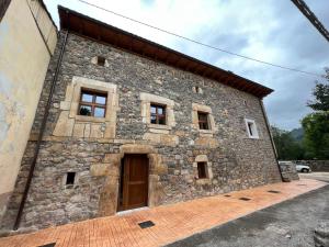 un antiguo edificio de piedra con puerta y ventanas en Palacio de Cambre en Soto de Cangas